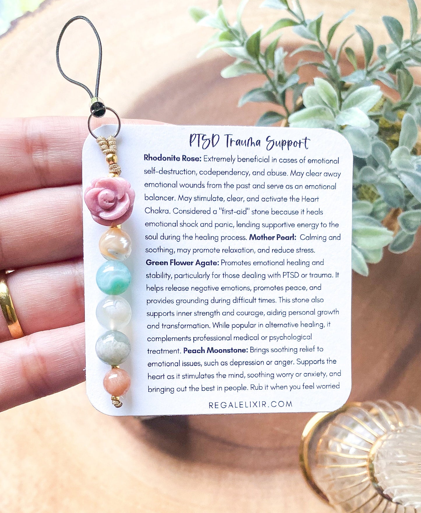 a person holding a bookmark with a flower on it