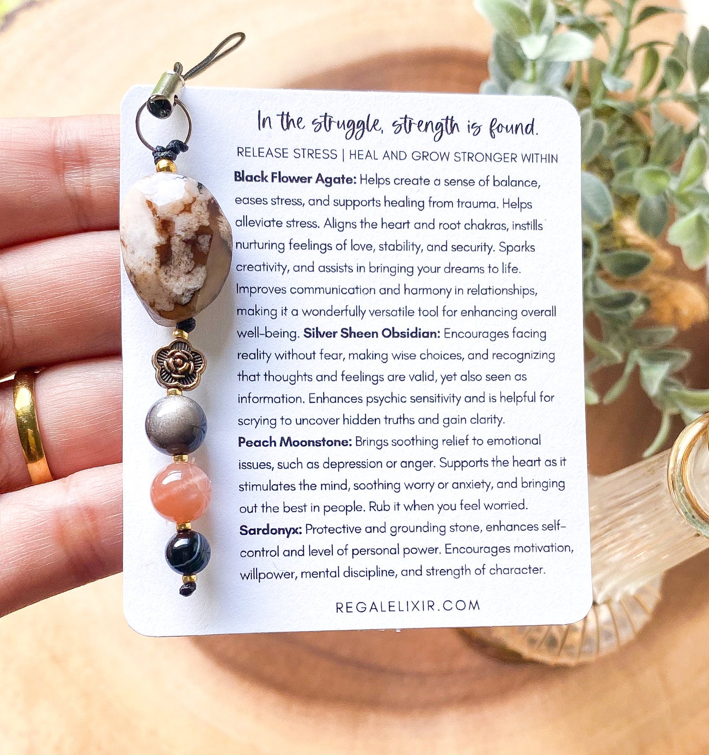 a person holding a card with a necklace on it