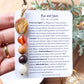 a person holding a bookmark with a bunch of beads on it